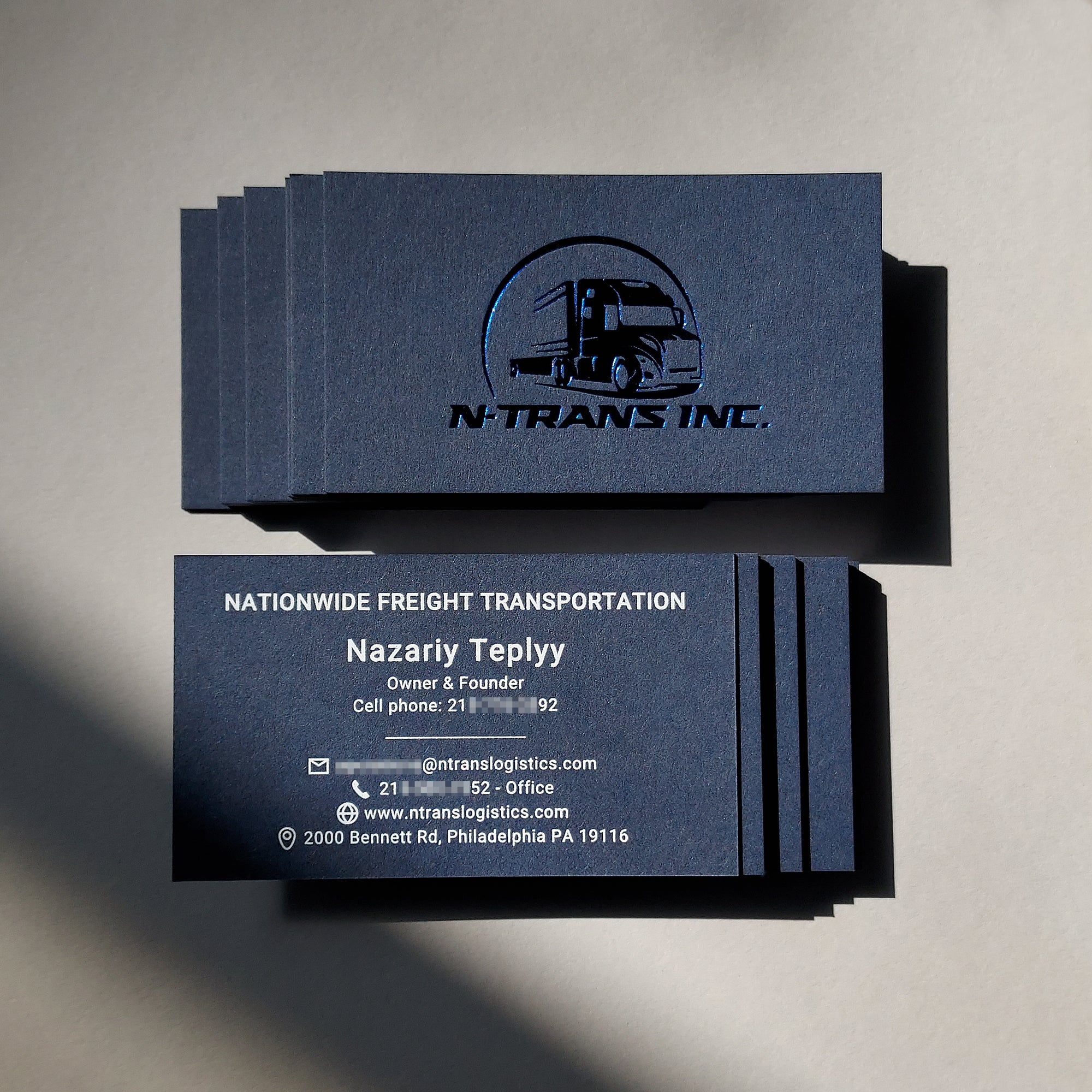Elegant handmade blue business card with thick stock and tailored foil embossing.