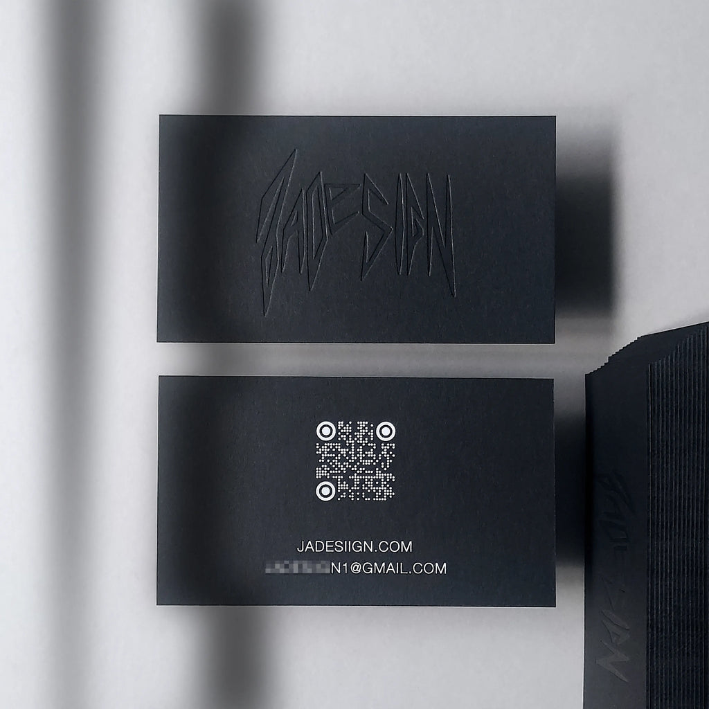 Experience the bold contrast of a 38pt black business card by OddPlanPrint, featuring a deep deboss and striking white foil.