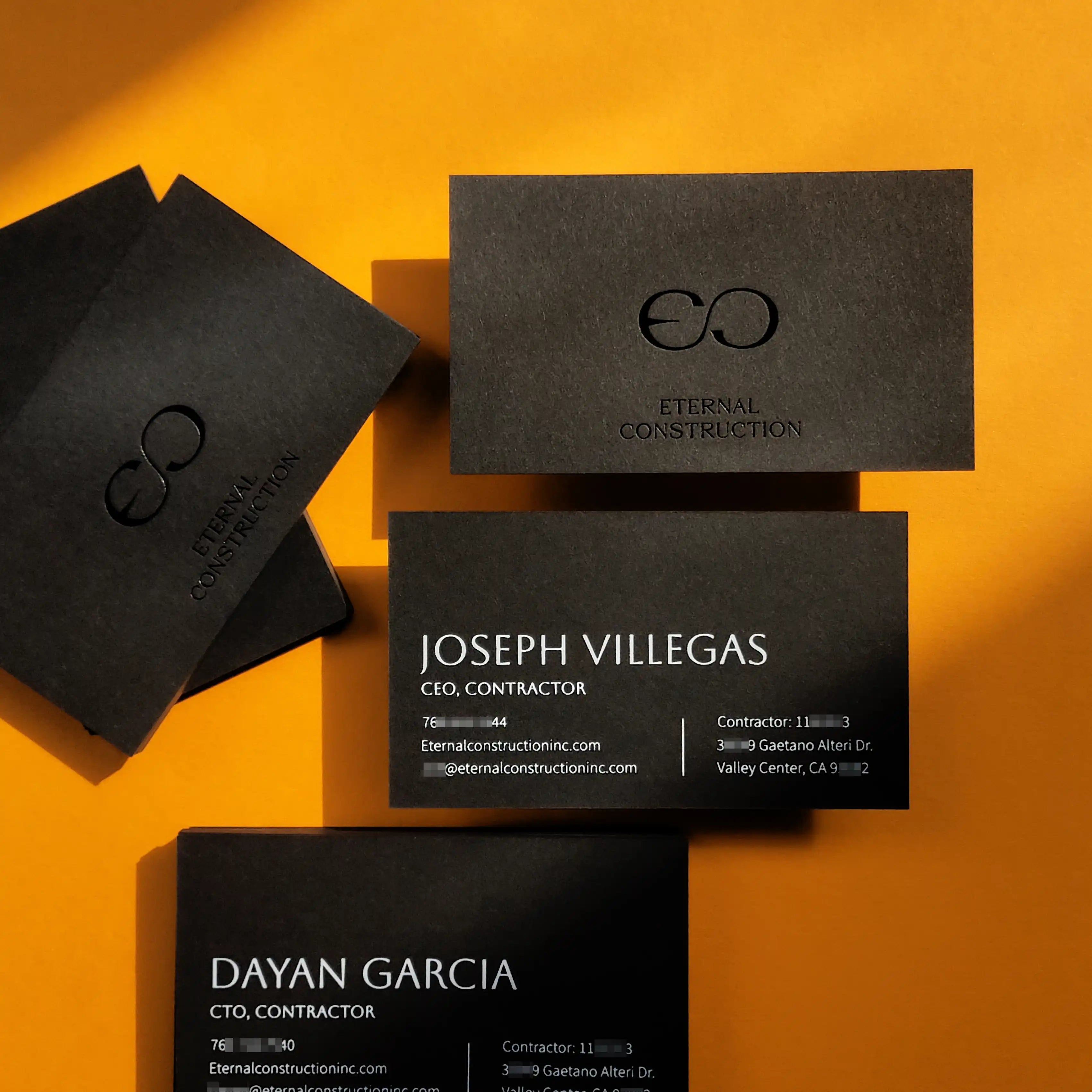 Thick 700gsm black business cards featuring glossy black foil and white foil by OddPlanPrint.