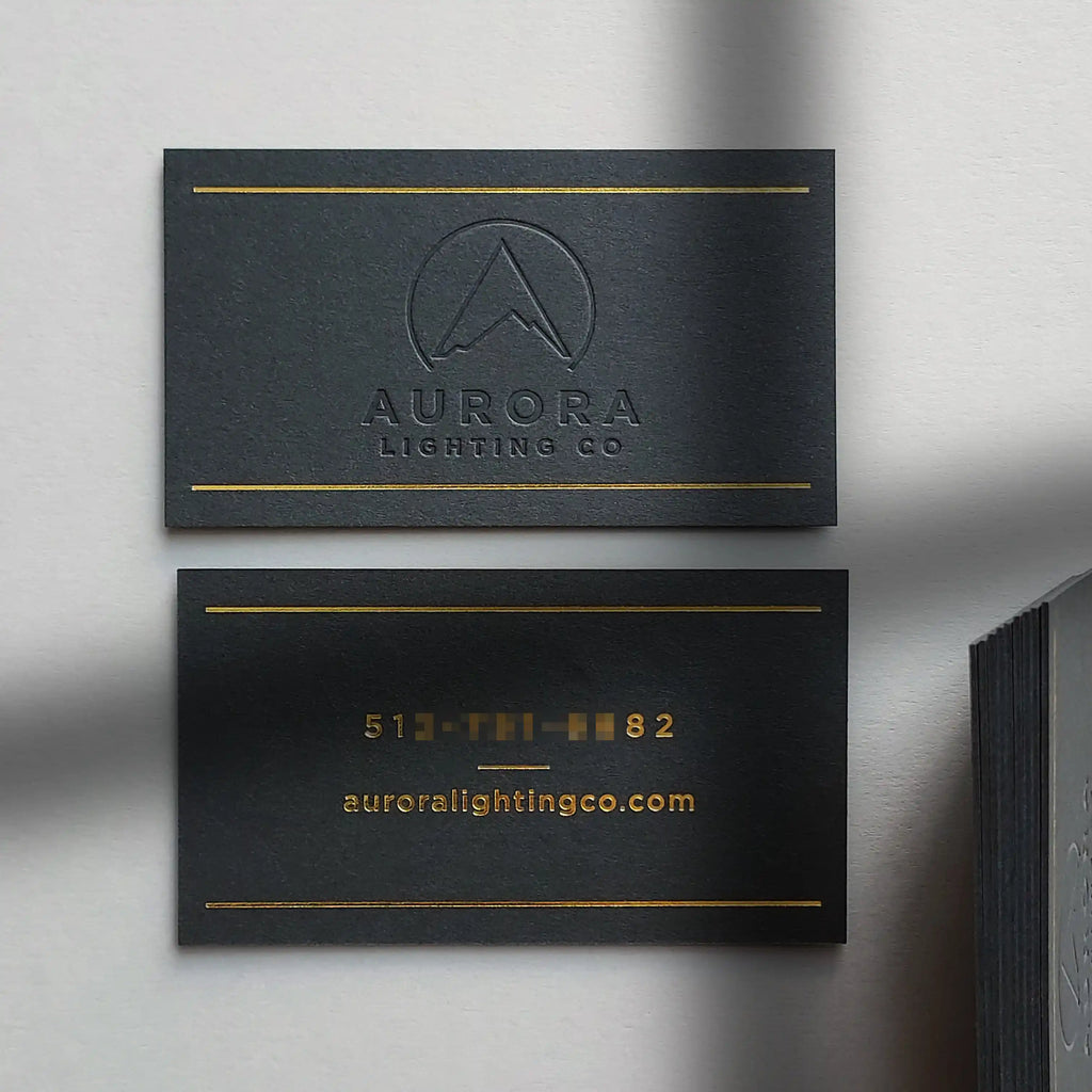 OddPlanPrint 38pt black paper business cards featuring deep debossed glossy gold foil branding.