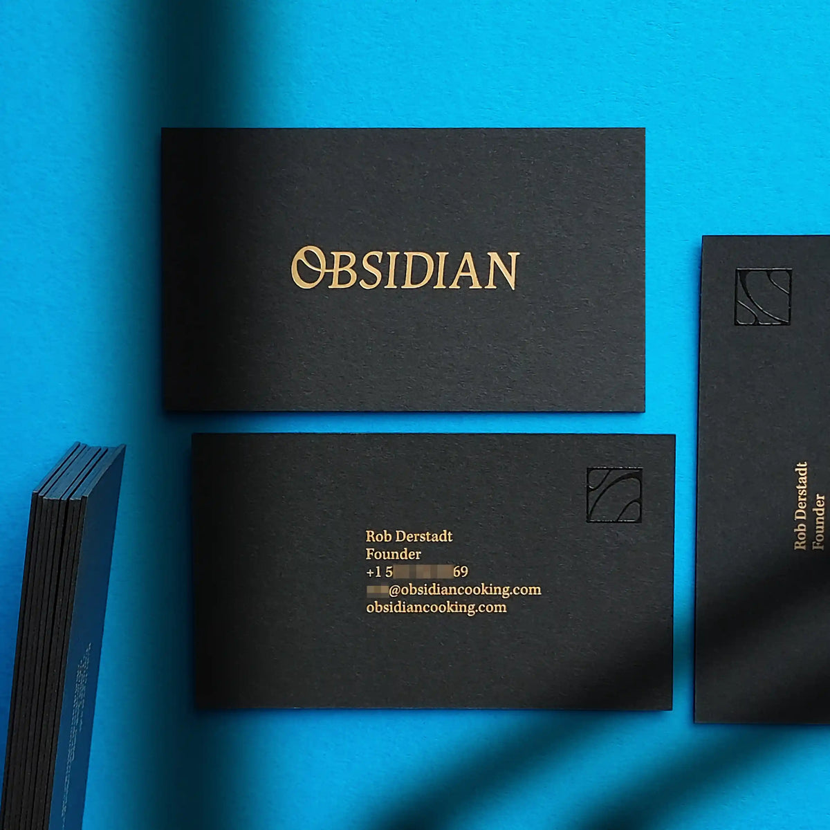Heavy 38pt black business cards showcasing matte gold foil and black spot gloss created by OddPlanPrint.