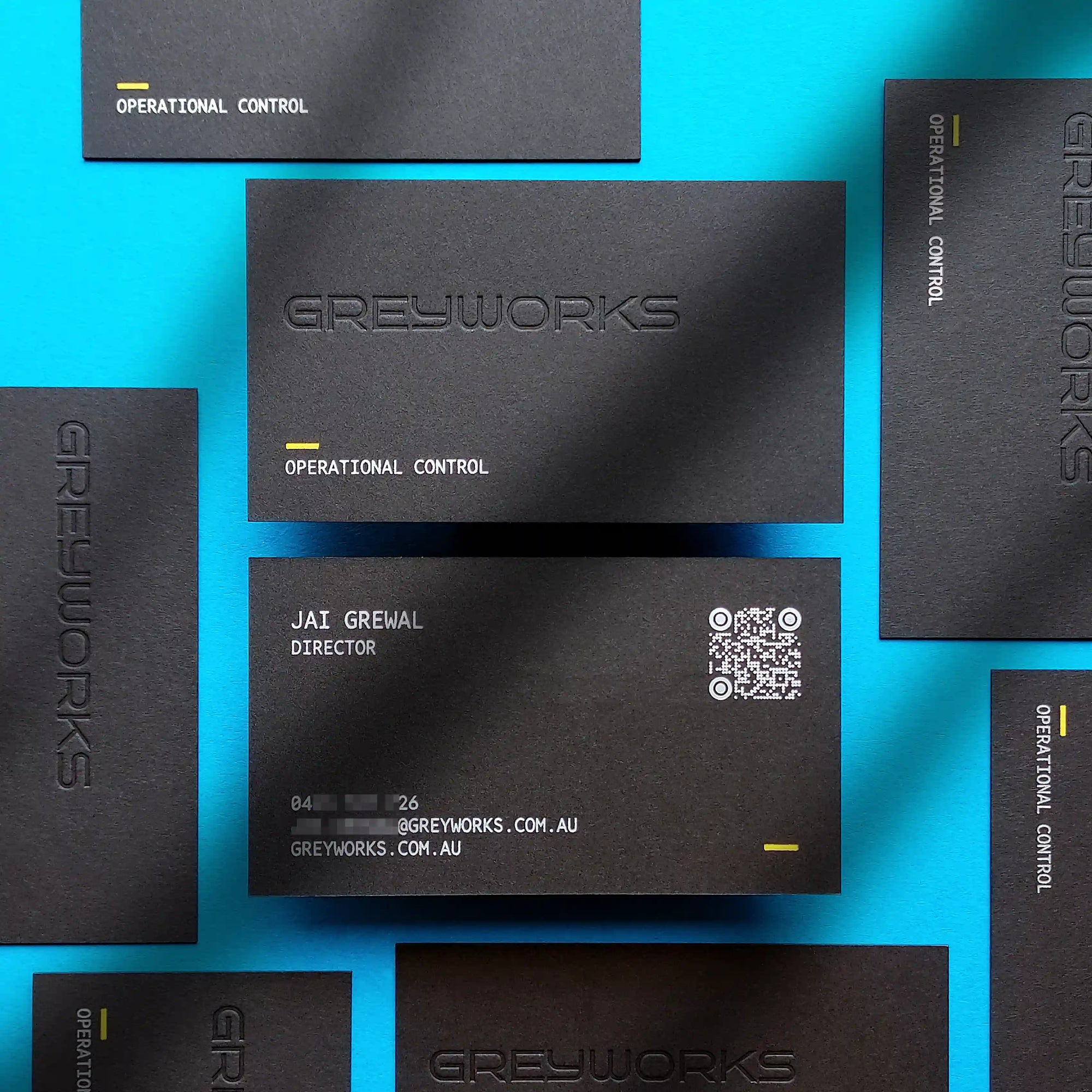Bespoke 700gsm black business cards with custom yellow hot foil details, matte silver branding, and standalone blind deboss sections engineered by OddPlanPrint.