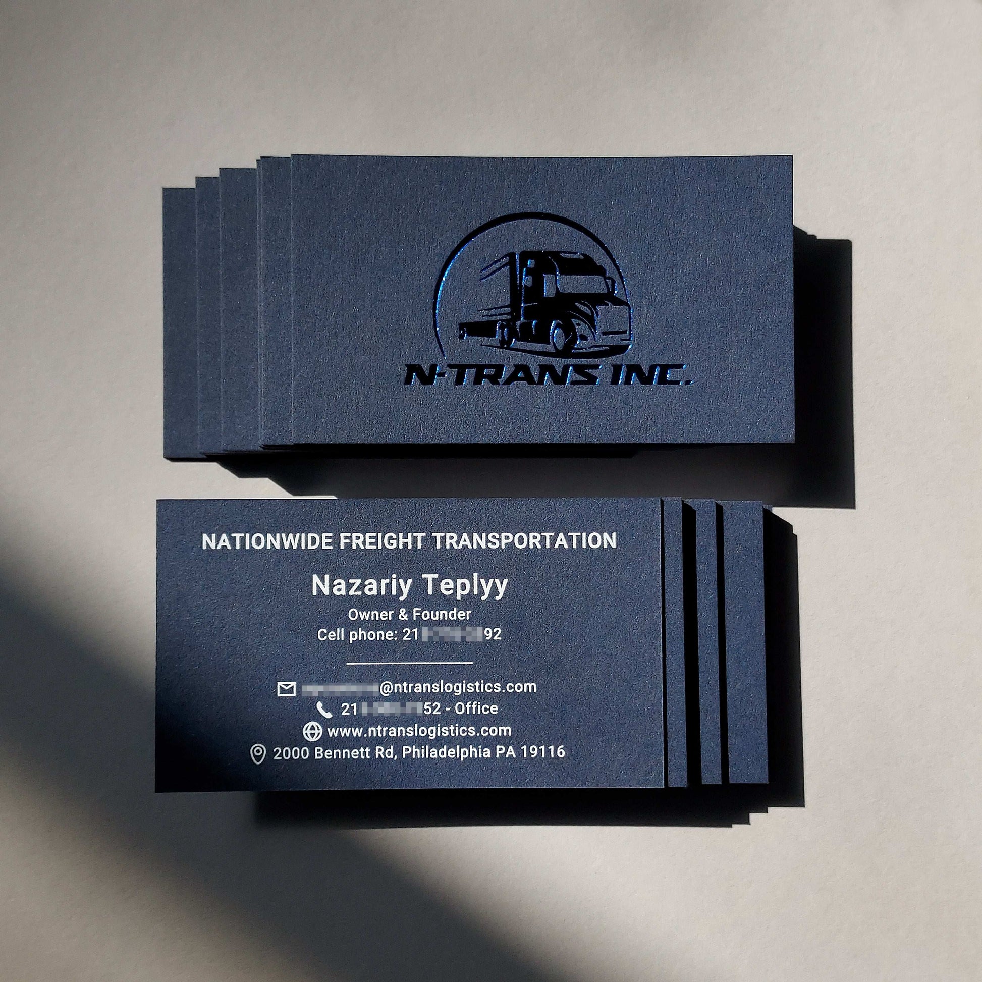 Elegant handmade blue business card with thick stock and tailored foil embossing.