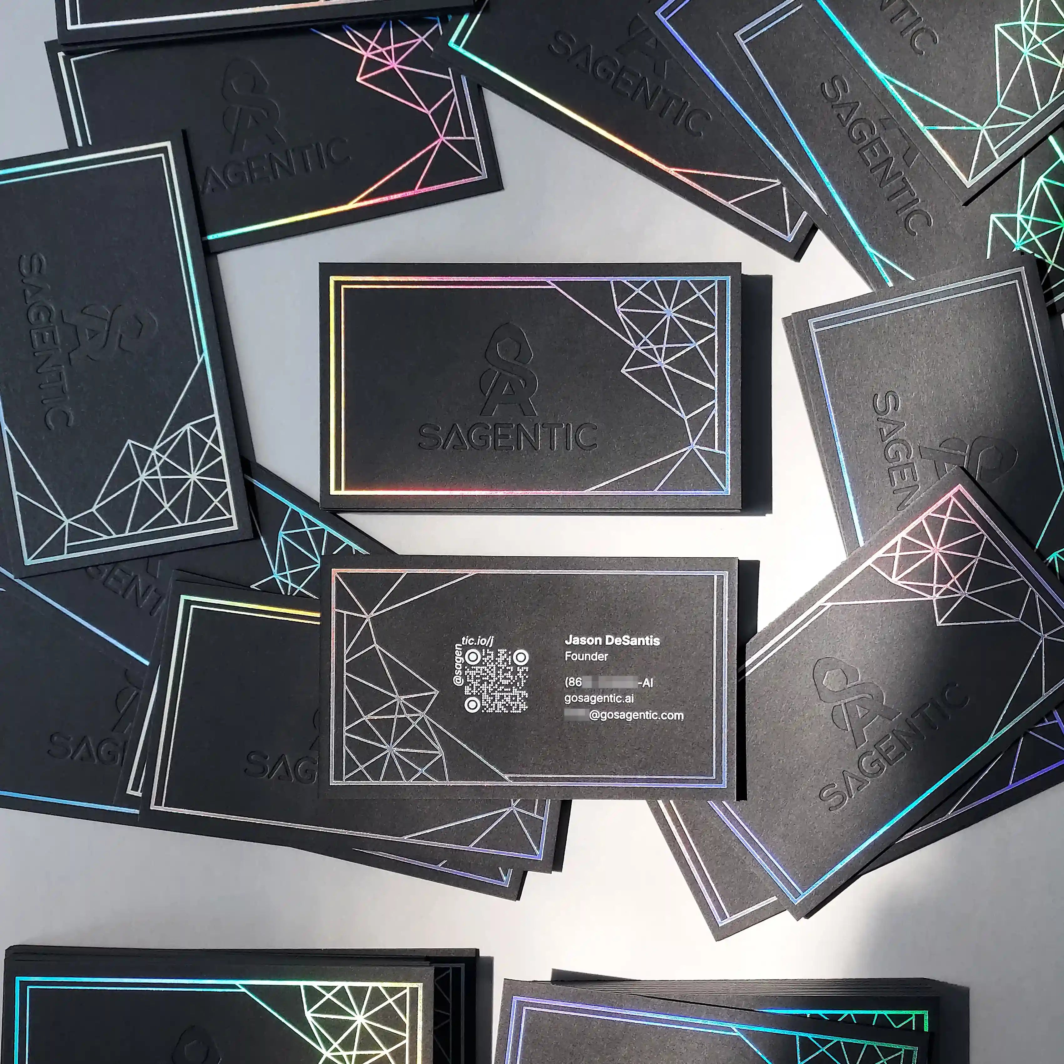 A striking 38pt black business card by OddPlanPrint, showcasing a vibrant hologram foil, a deep deboss, and clean white foil details.
