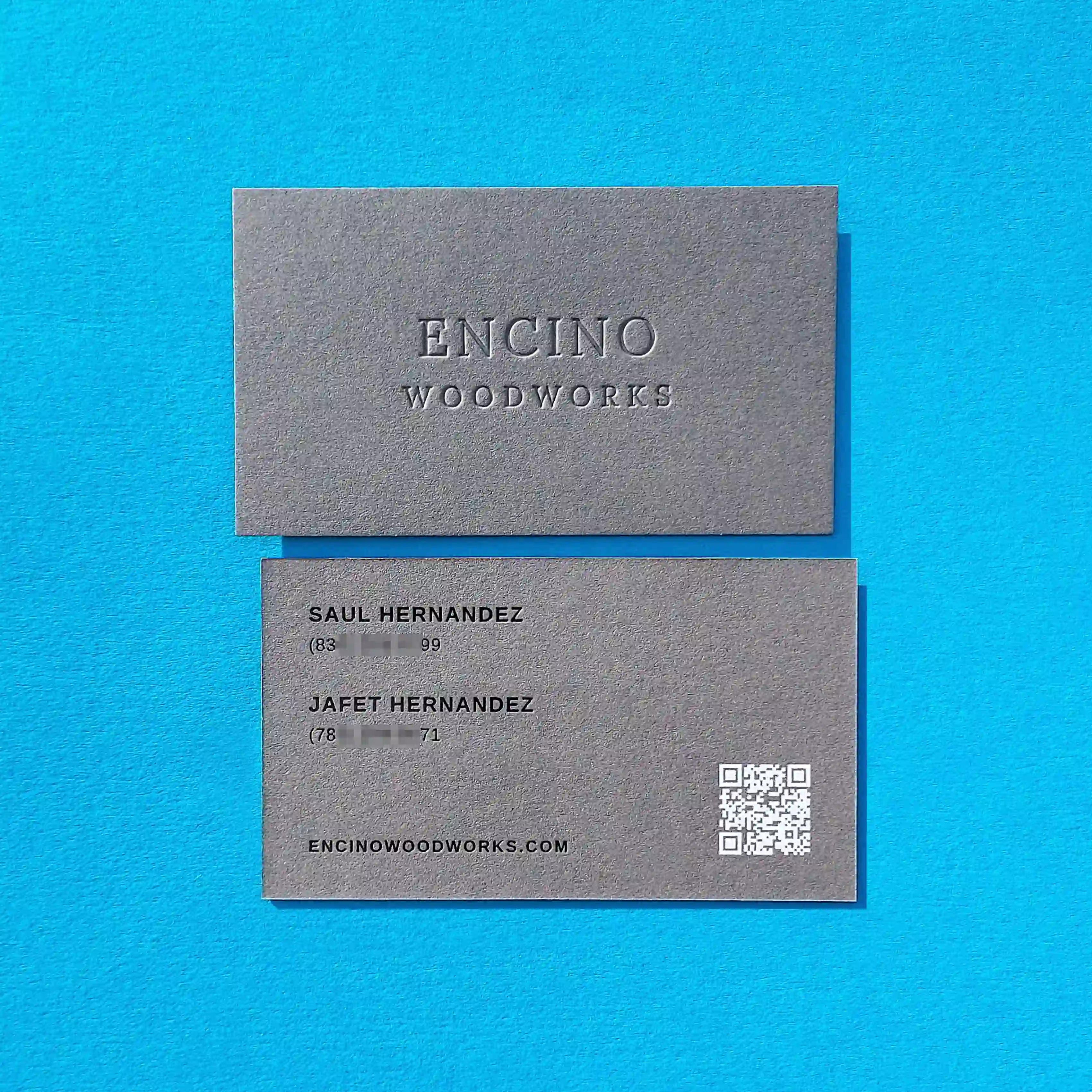 Dark grey business cards 30pt 540gsm with deboss, black foil and white foil produced by OddPlanPrint.