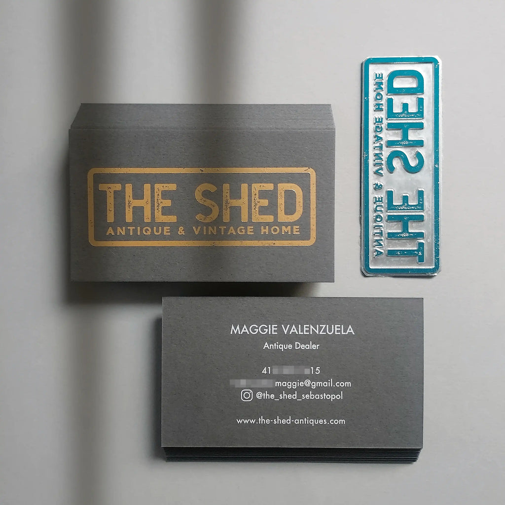 Elegant dark grey business cards featuring gold foil logo and white foil name details - OddPlanPrint