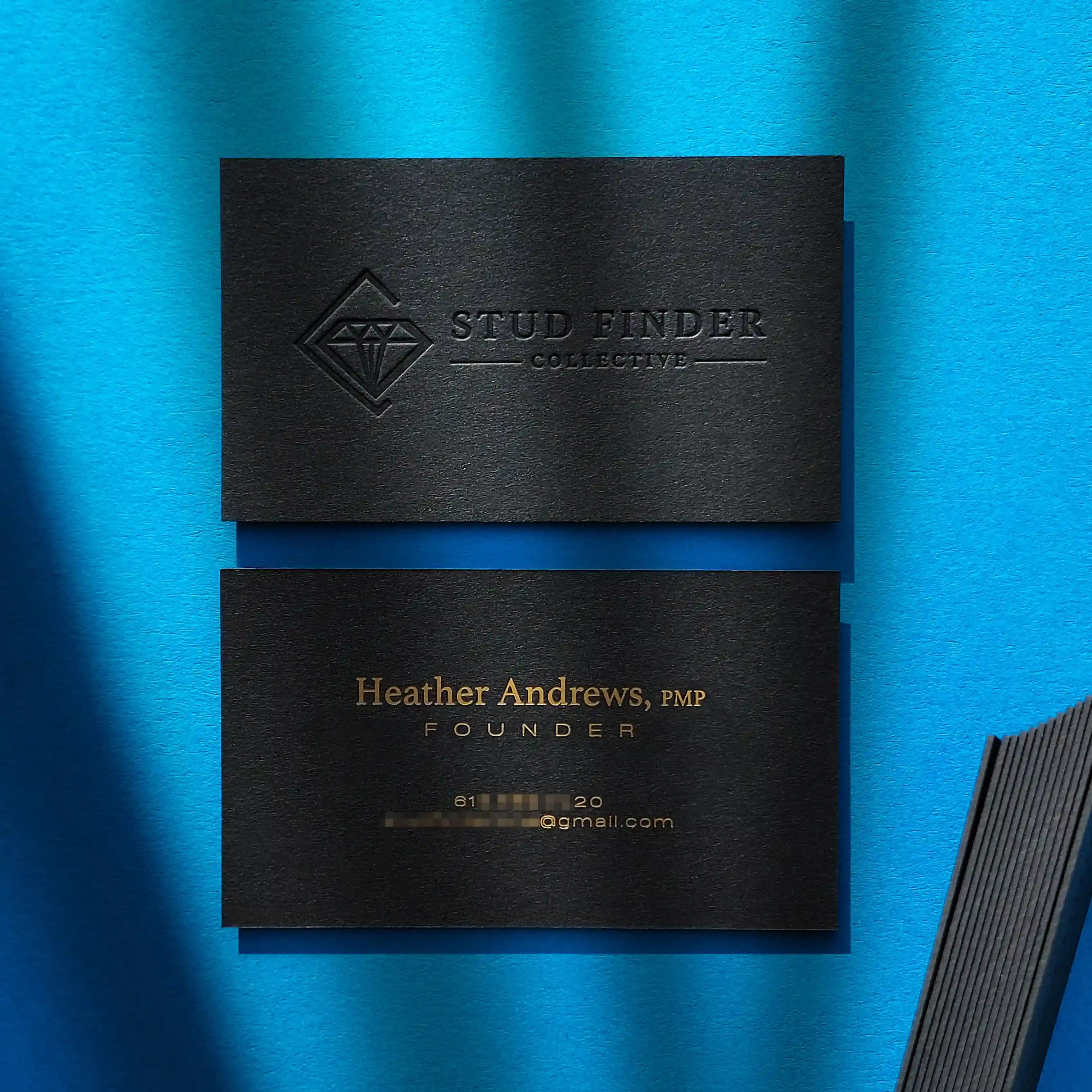 Debossed black business cards 38pt with matte gold foil by OddPlanPrint.