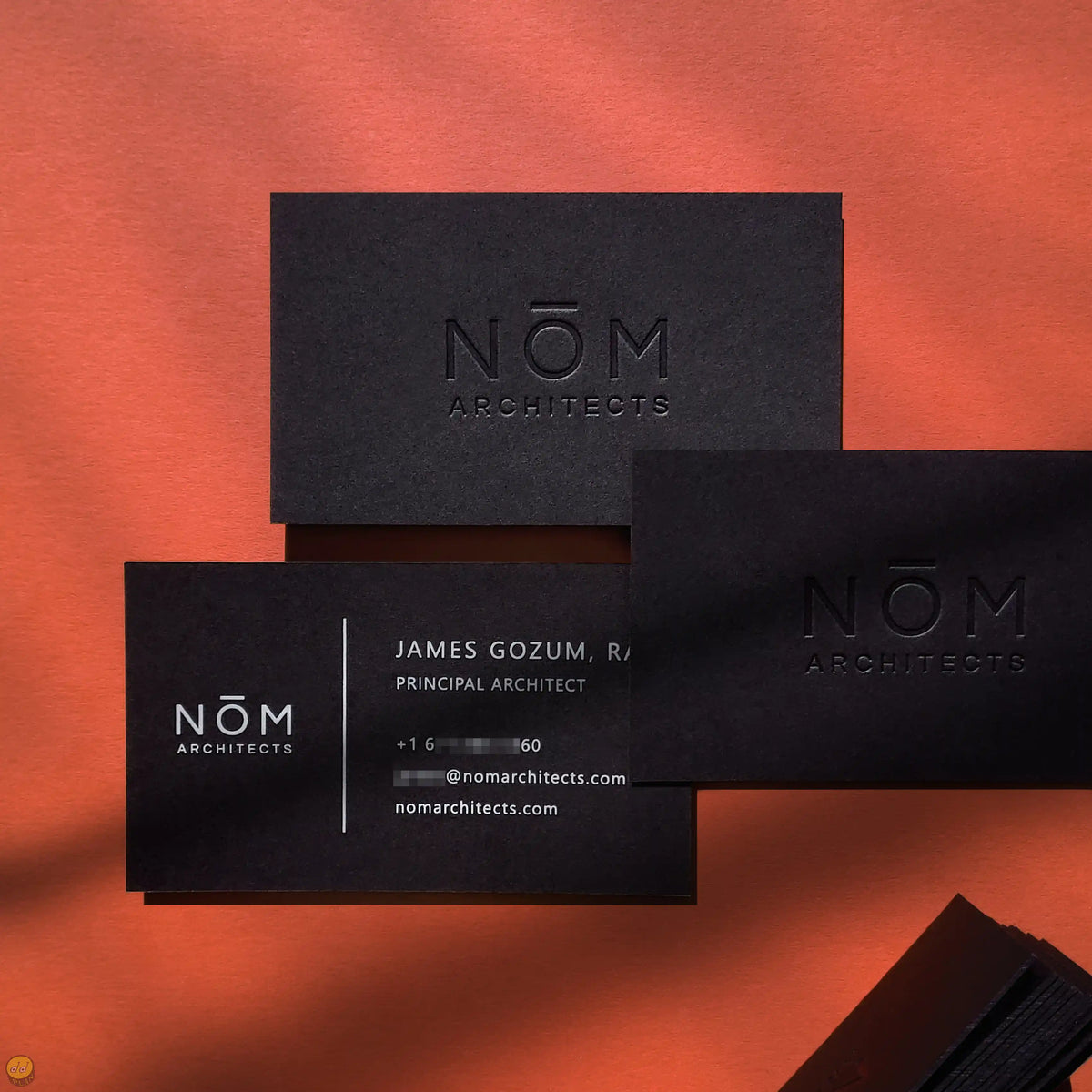 Heavy black business cards finished with deboss and white ink by OddPlanPrint.