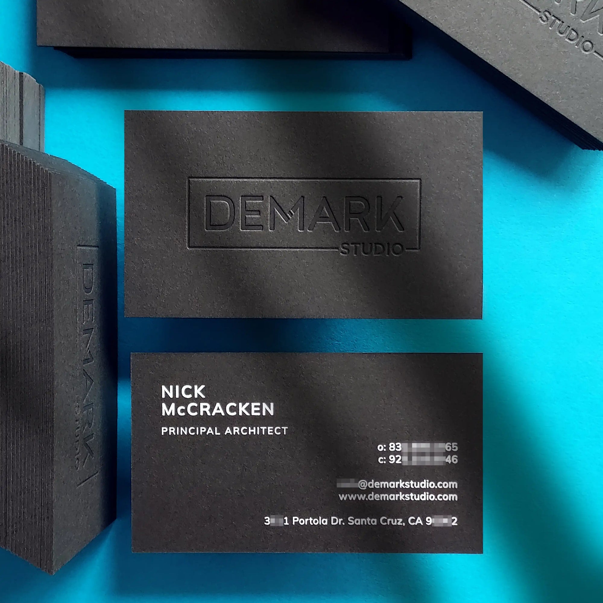 Debossed black business cards 38pt with clean deboss and white foil finished by OddPlanPrint.