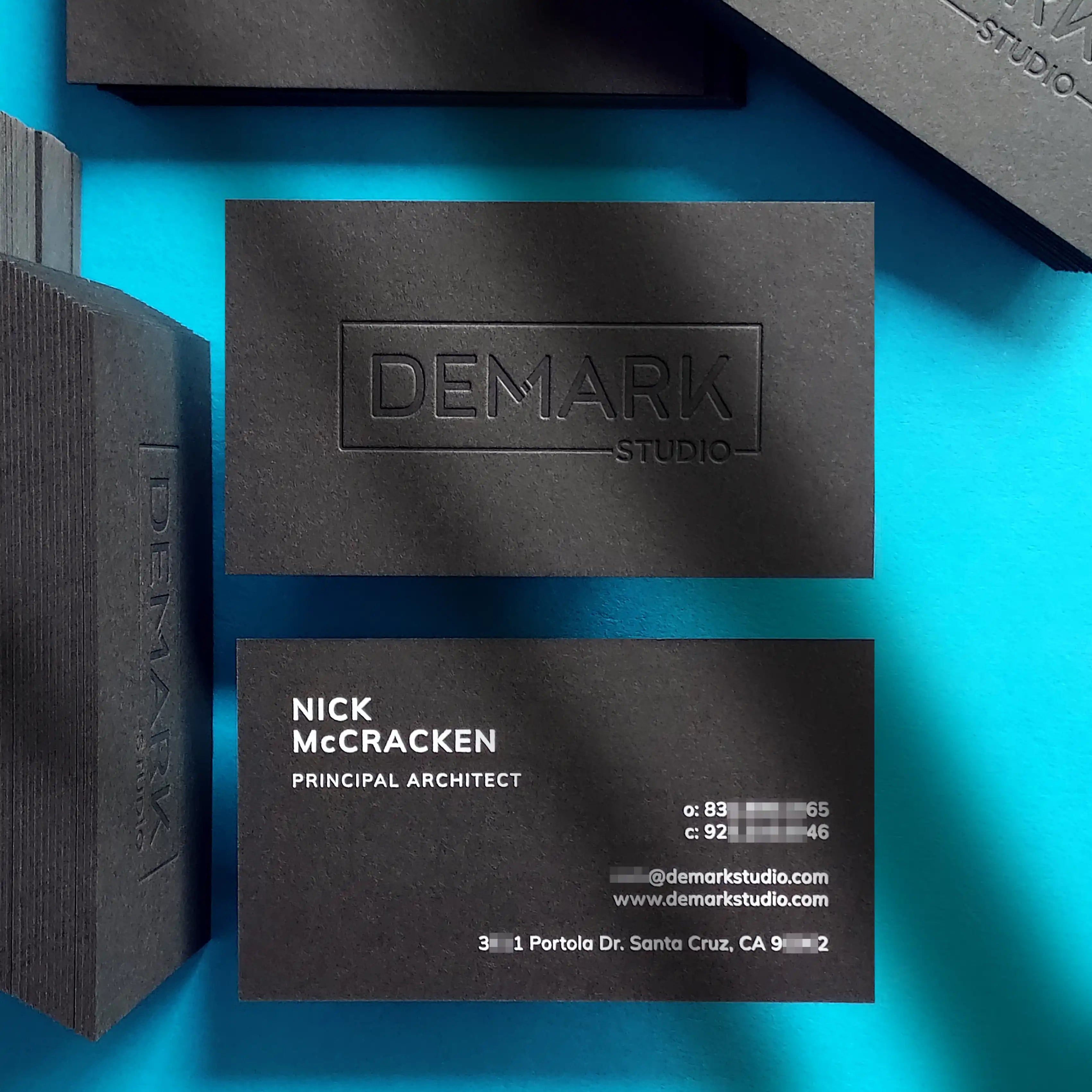 Debossed black business cards 38pt with clean deboss and white foil finished by OddPlanPrint.