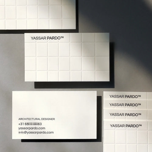Elegant cotton 45pt thick debossed business cards showing blind deboss and glossy black foil produced by OddPlanPrint.