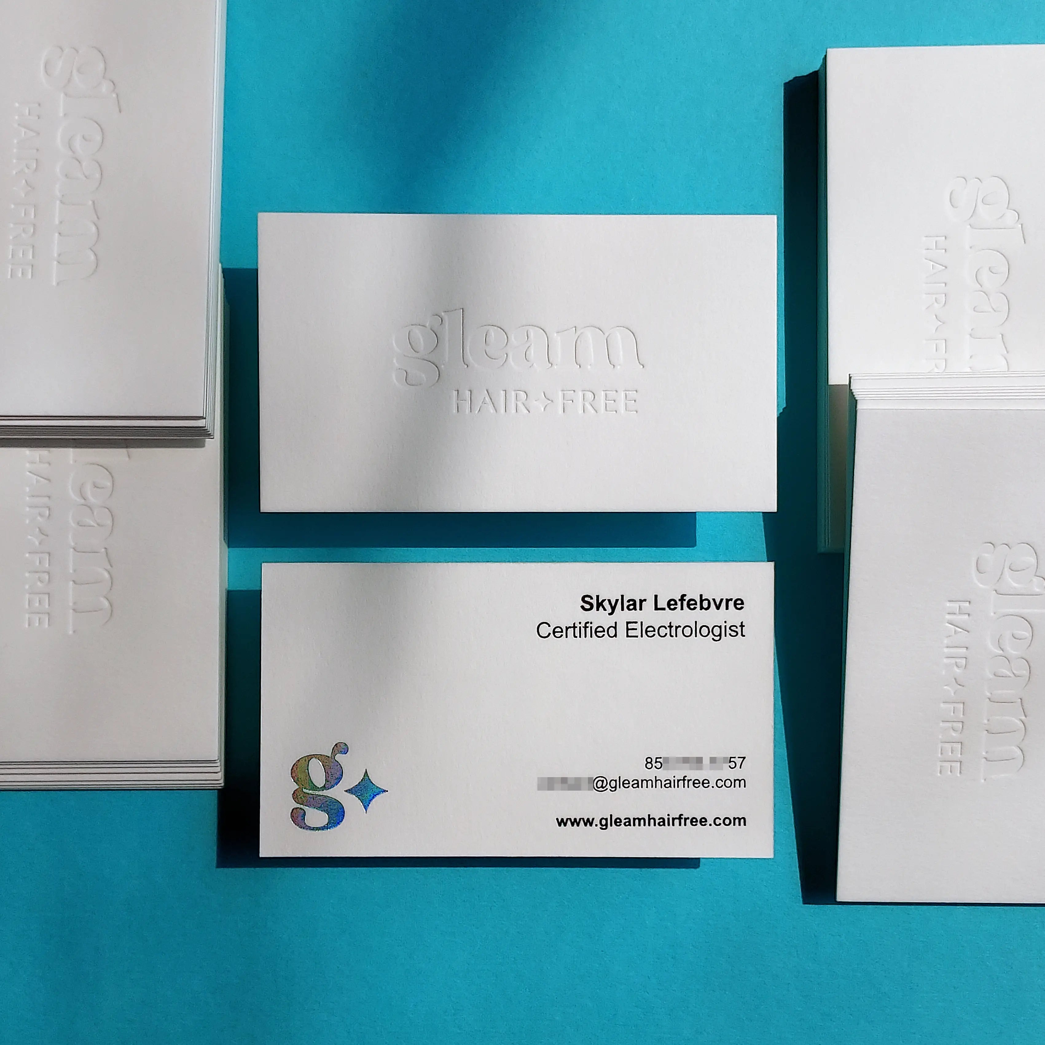 45pt cotton debossed business cards featuring front deboss and holographic, black foil on the back by OddPlanPrint