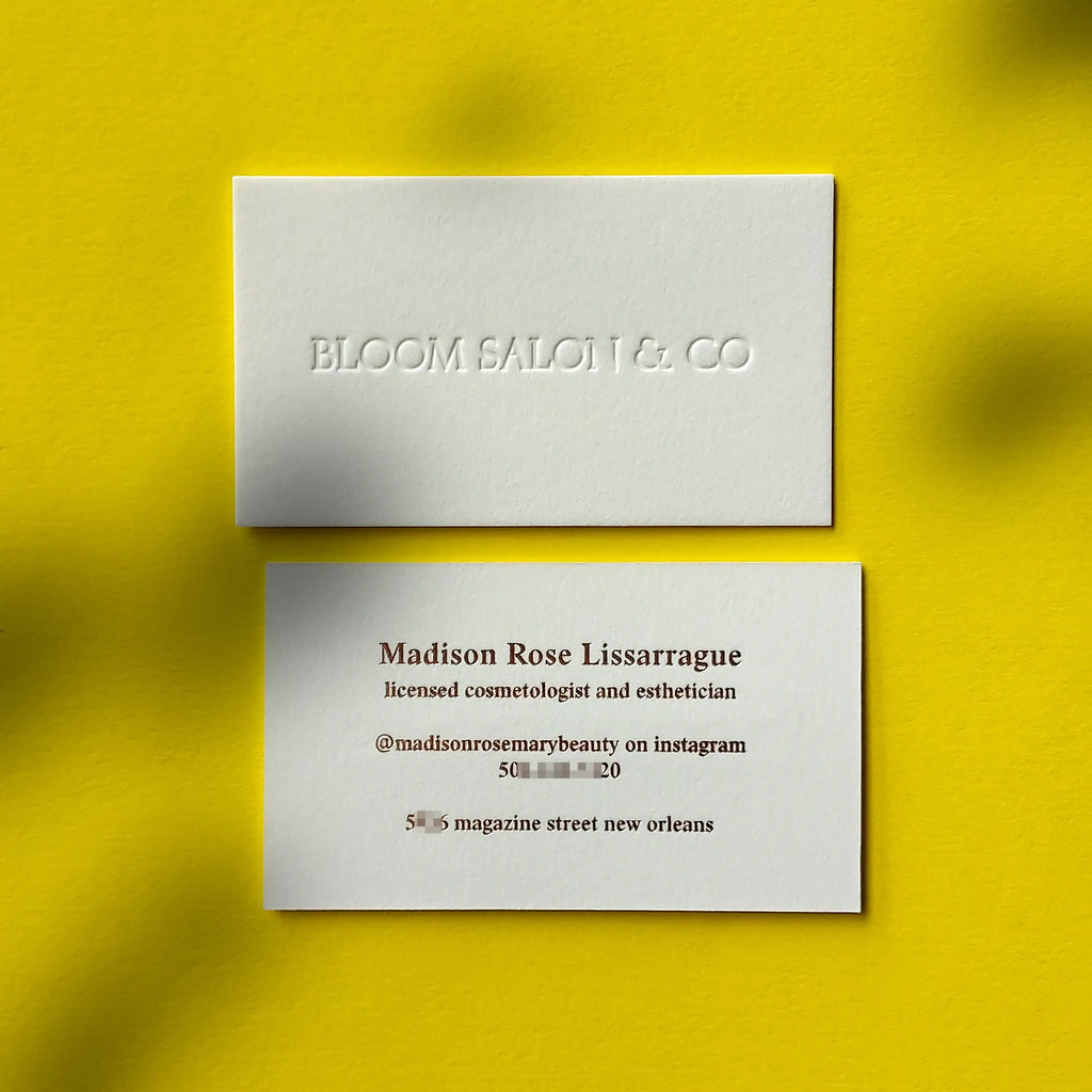 Thick cotton debossed business cards featuring rose gold foil accents made by OddPlanPrint.