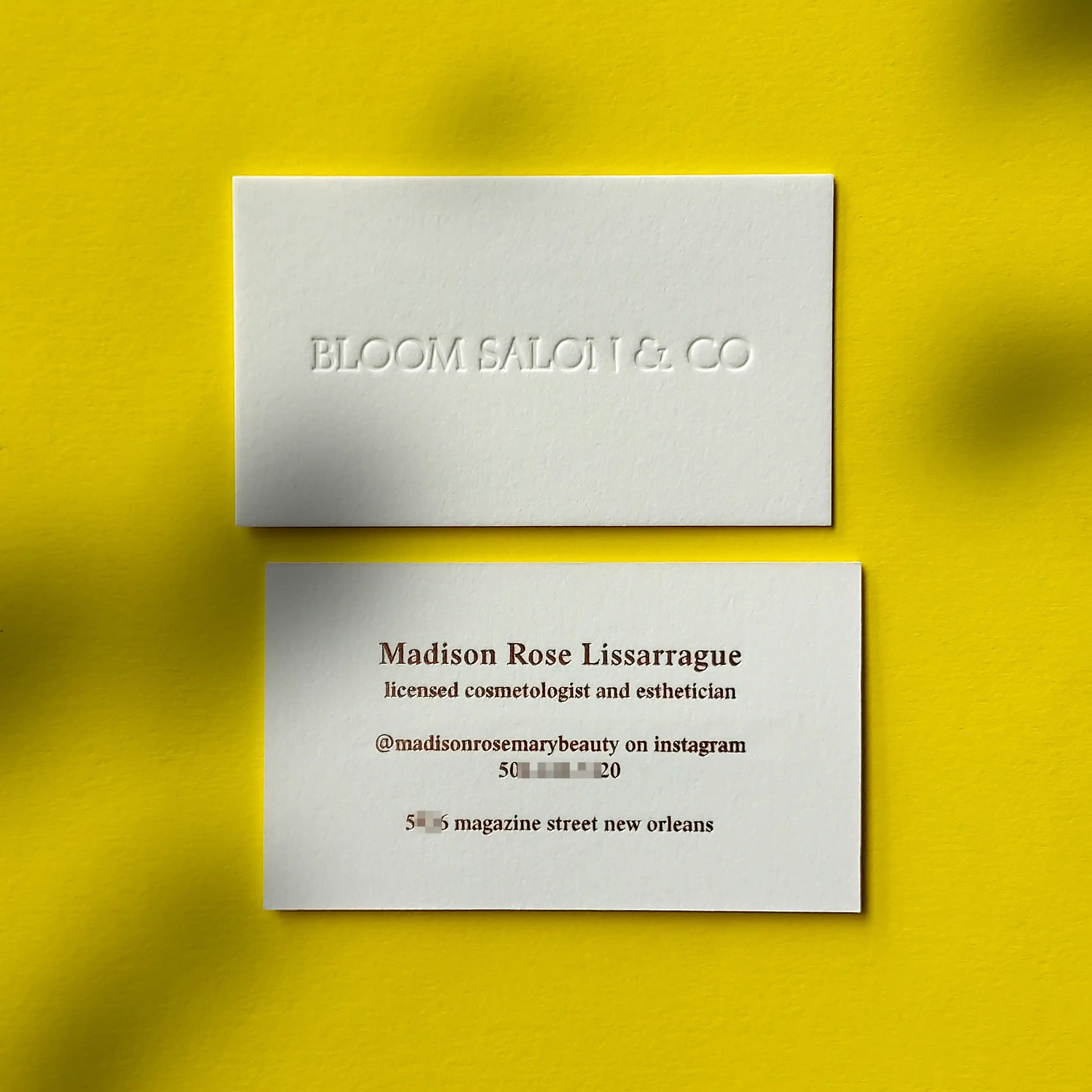 Thick cotton debossed business cards featuring rose gold foil accents made by OddPlanPrint.