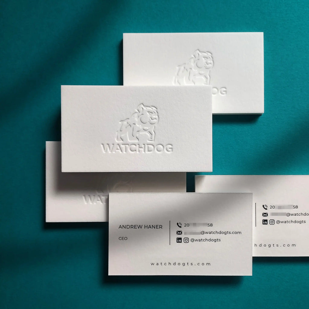 45pt cotton business card with deep debossed design and glossy black foil on matte black stock, showing recessed depth.