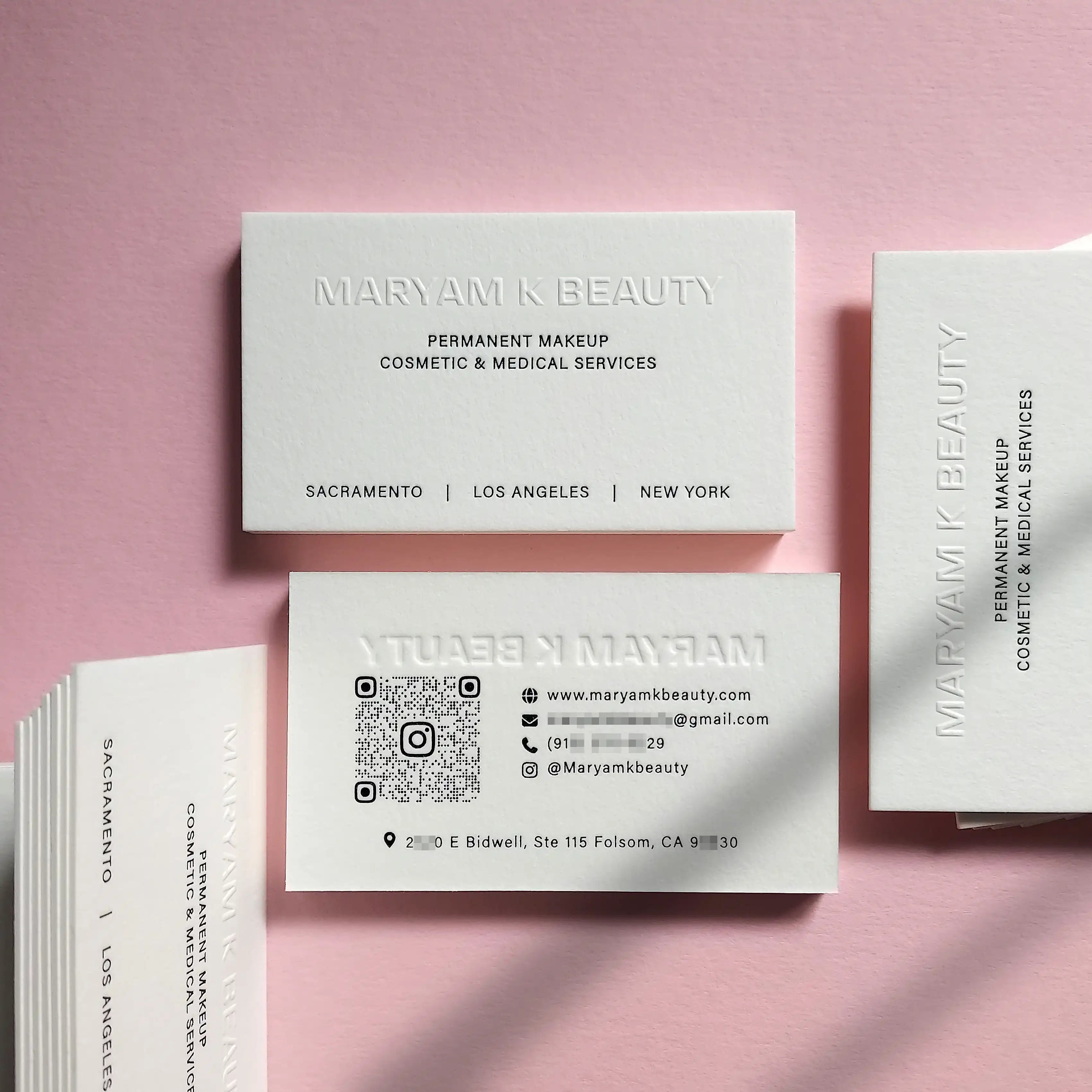 Stacked 45pt cotton cards with glossy black foil and embossing on both sides, highlighting premium finish.