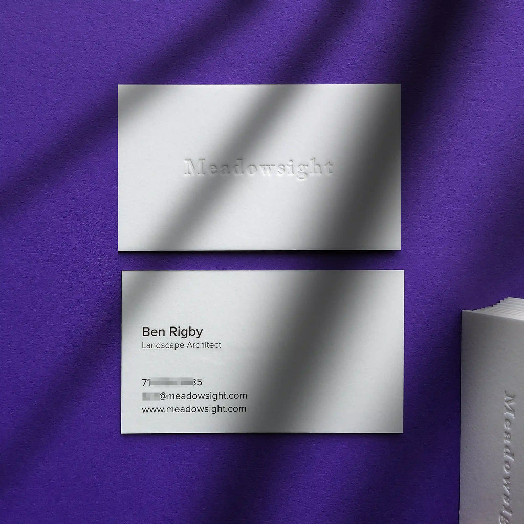 High-end 45pt cotton paper business cards with blind debossed texture and clean black text finished by OddPlanPrint.