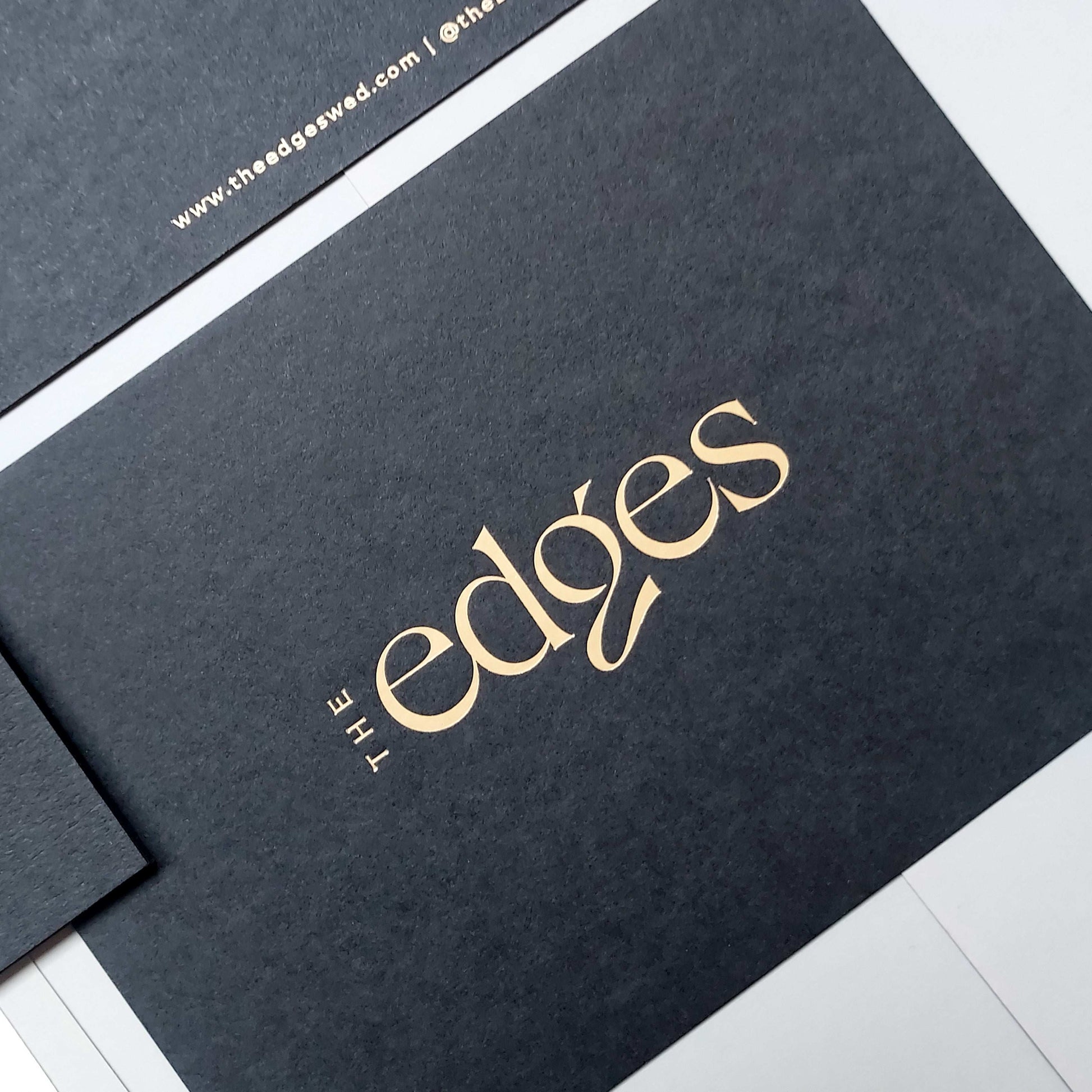 Elegant matte black postcard with blind deboss and foil finish.