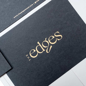 Elegant matte black postcard with blind deboss and foil finish.