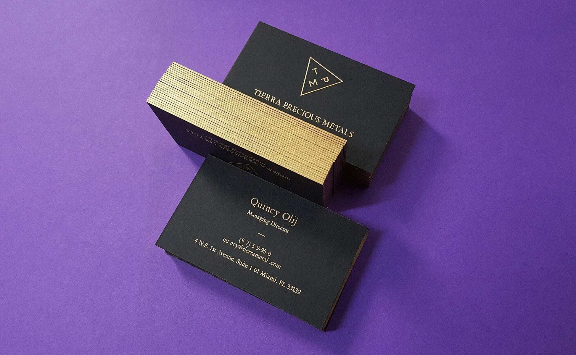 Golden-edged black card with thick paper and fine foil accents.