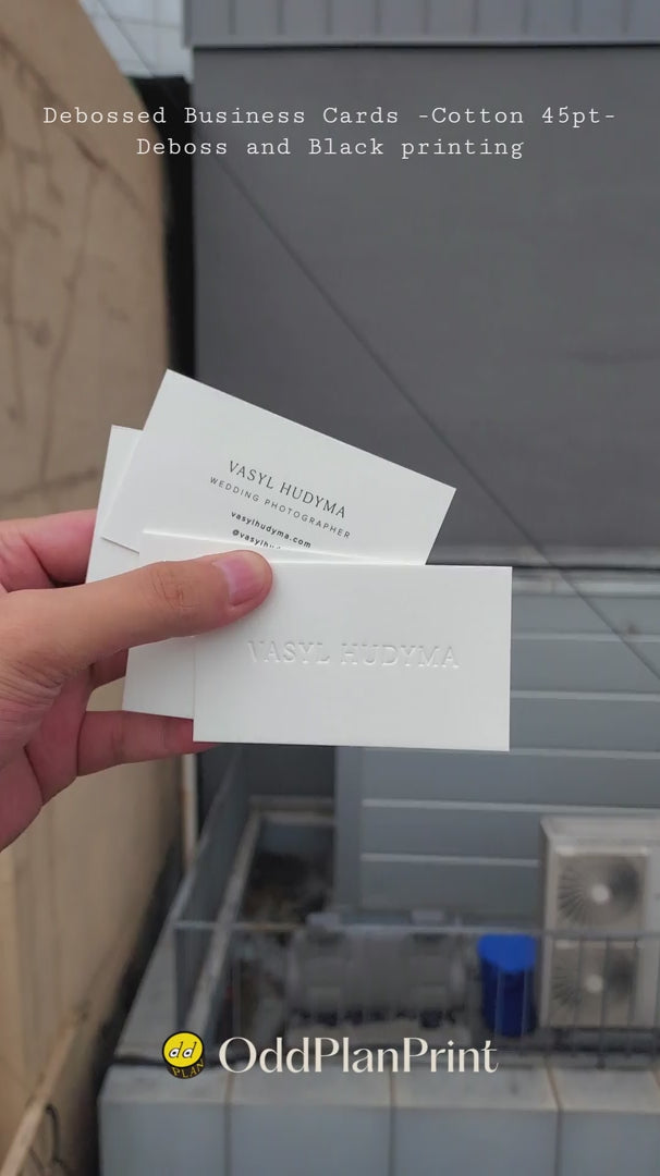 Luxury debossed business cards on 45pt cotton stock with black printing produced by OddPlanPrint.