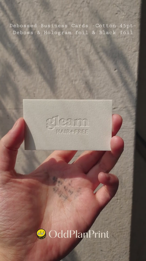 Thick 45pt cotton business cards debossed on front and hologram and black foil on back made by OddPlanPrint