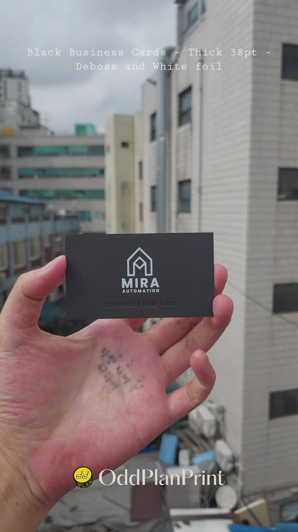 Premium black 38pt debossed business cards featuring white foil accents from OddPlanPrint.
