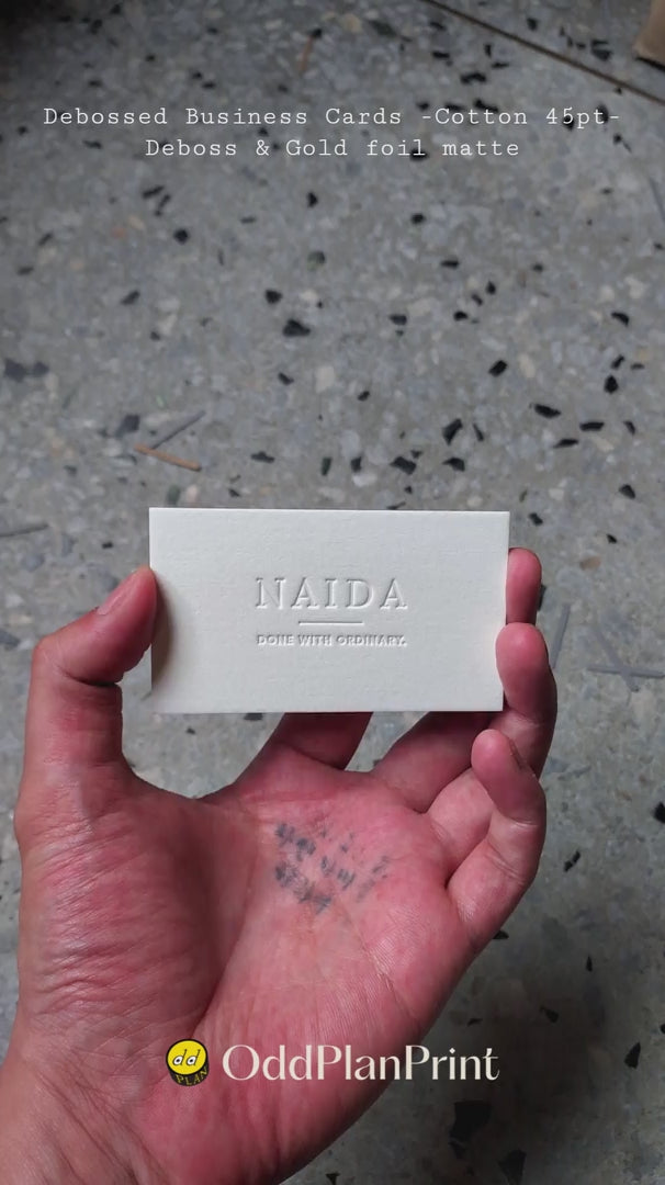 High-end 750gsm cotton business cards from OddPlanPrint featuring deep debossing techniques and metallic gold matte foil accents.
