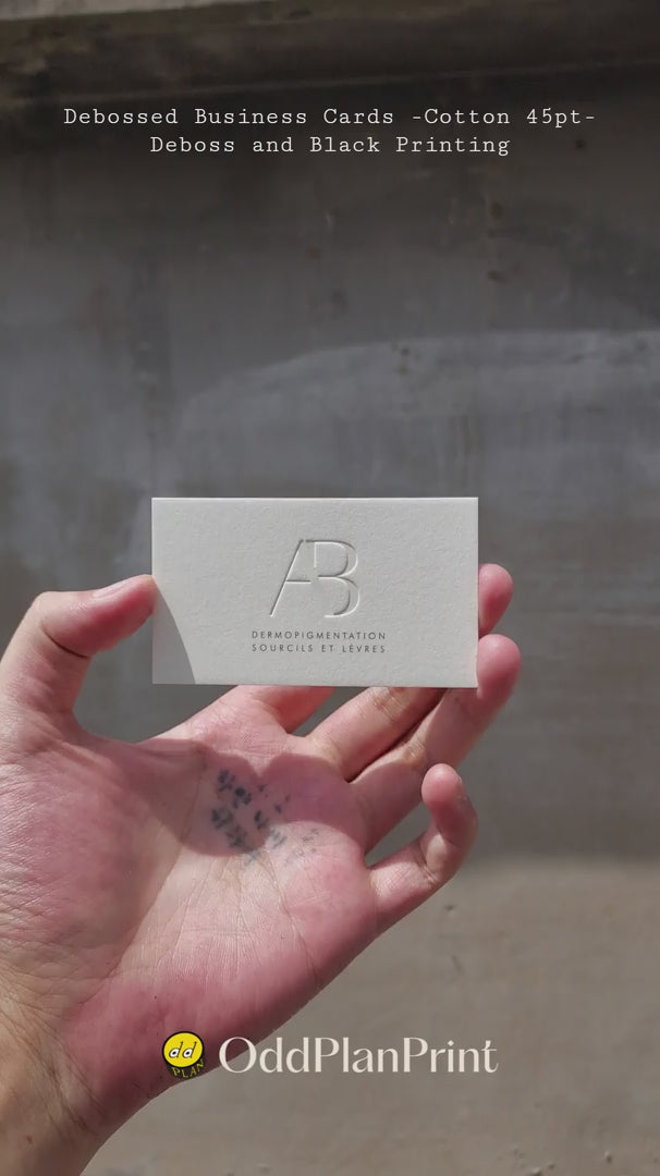 Premium 45pt cotton business cards with deep debossing and black ink finish produced by OddPlanPrint.