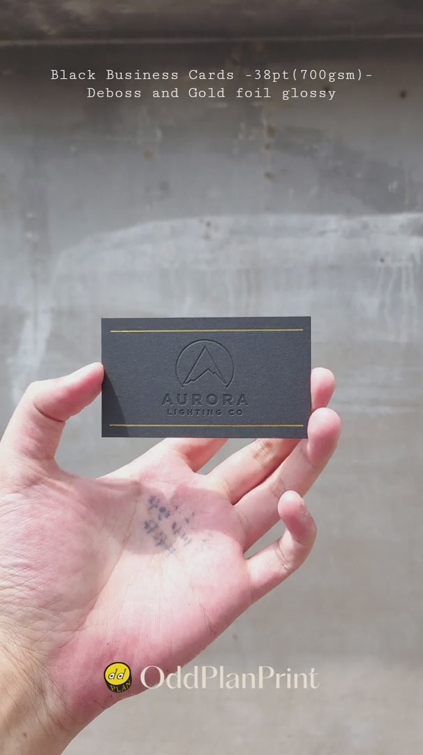 Premium 38pt black business cards showcasing shiny gold foil and deboss finish by OddPlanPrint.