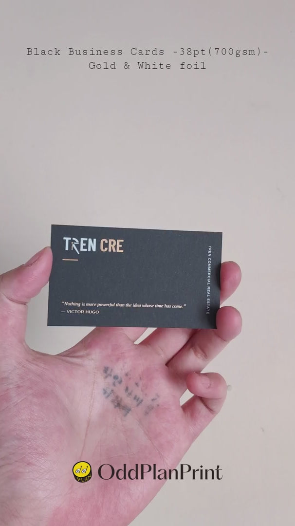 Bespoke 38pt black paper business cards with dual gold and white foil finish produced by luxury printer OddPlanPrint.