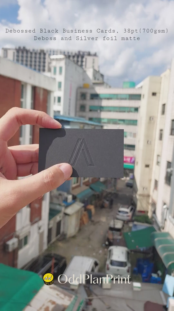Thick black business cards featuring deboss and matte silver foil from OddPlanPrint.