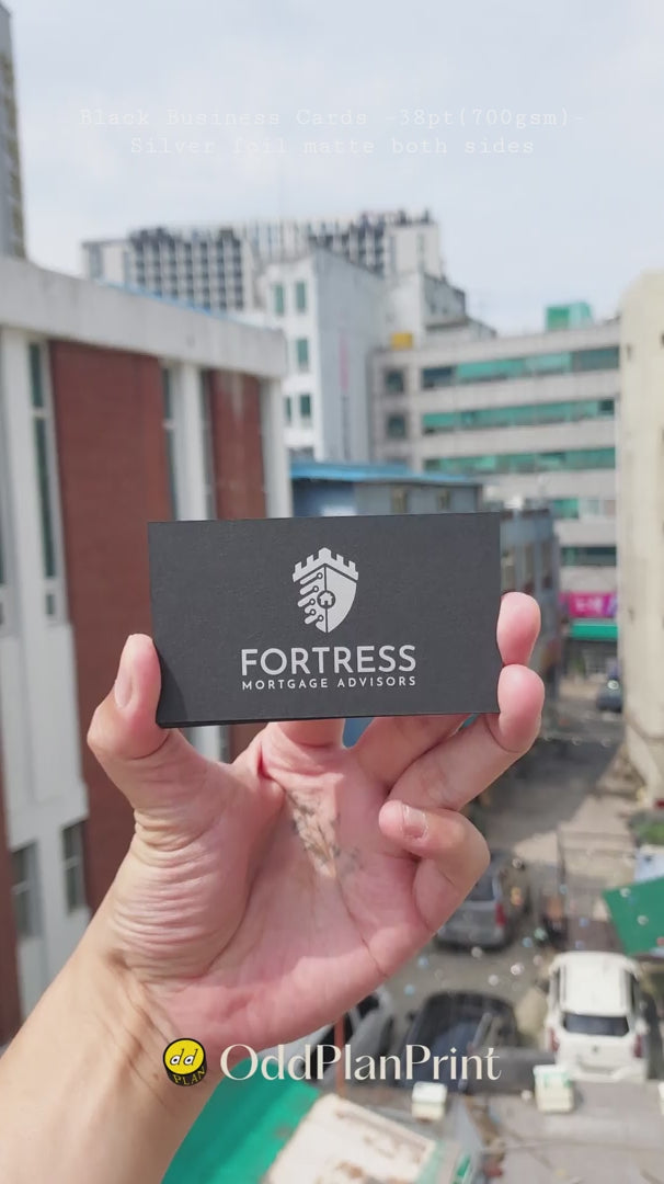 Premium 38pt black paper business cards displaying two-sided matte silver foil branding finished by OddPlanPrint.