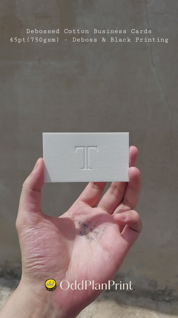Debossed cotton business cards 45pt by OddPlanPrint - deep blind deboss with black printing on premium 750gsm cotton stock. Custom luxury business cards with tactile finish.