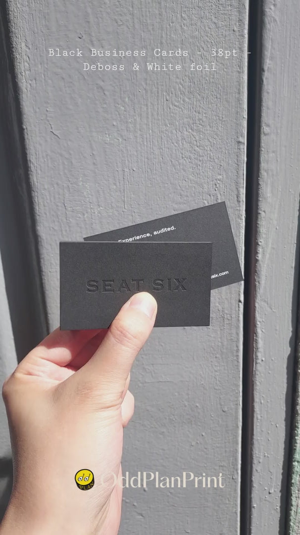 OddPlanPrint presents a 38pt black business card featuring a deep deboss and crisp white foil. This design offers a sophisticated tactile experience.