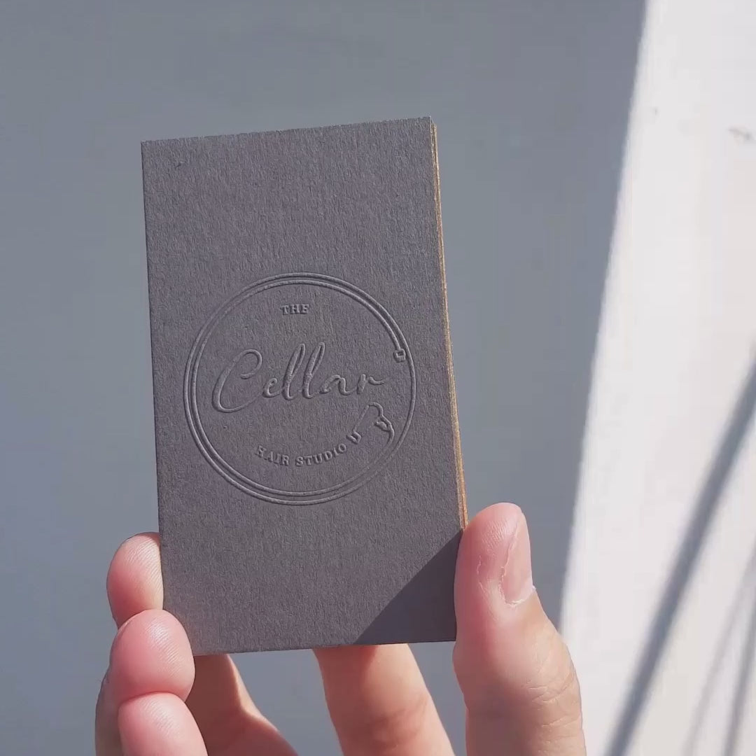 Thick custom dark grey card with deboss and elegant branding.