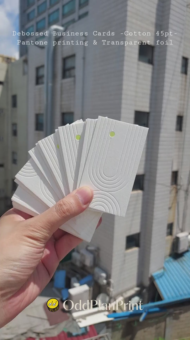 Elegant 45pt cotton debossed business cards combining blind deboss texture with transparent foil and Pantone printing made by OddPlanPrint.