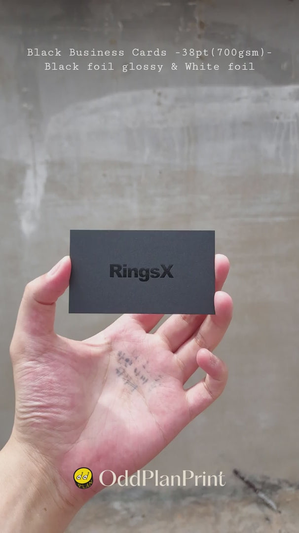 Premium 38pt black business cards showcasing glossy black foil depth and white foil details created by OddPlanPrint.