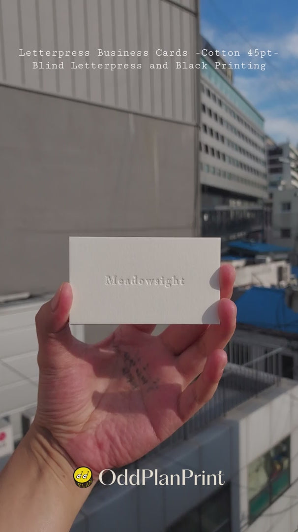 Minimalist 45pt cotton business cards displaying blind letterpress logo and black ink detailing created by OddPlanPrint.