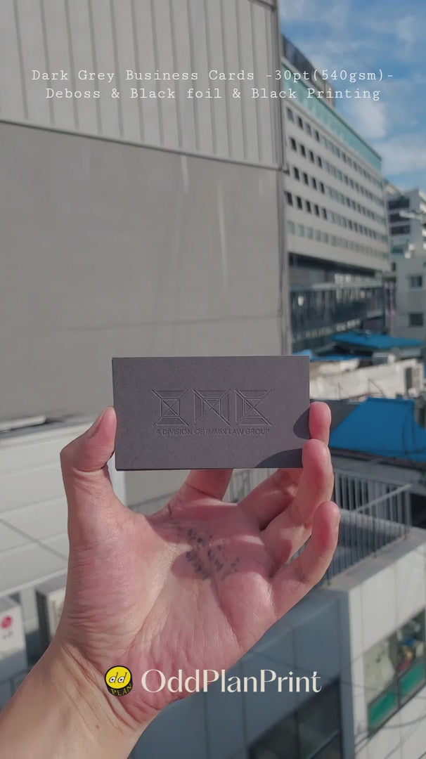 Premium Debossed dark grey business cards with glossy black foil accents and black ink printed by OddPlanPrint.