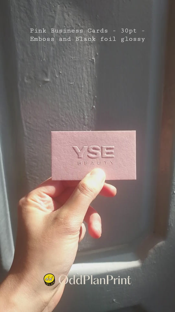 Premium pink business card with raised emboss and glossy black foil accents printed on thick 30pt paper by OddPlanPrint.