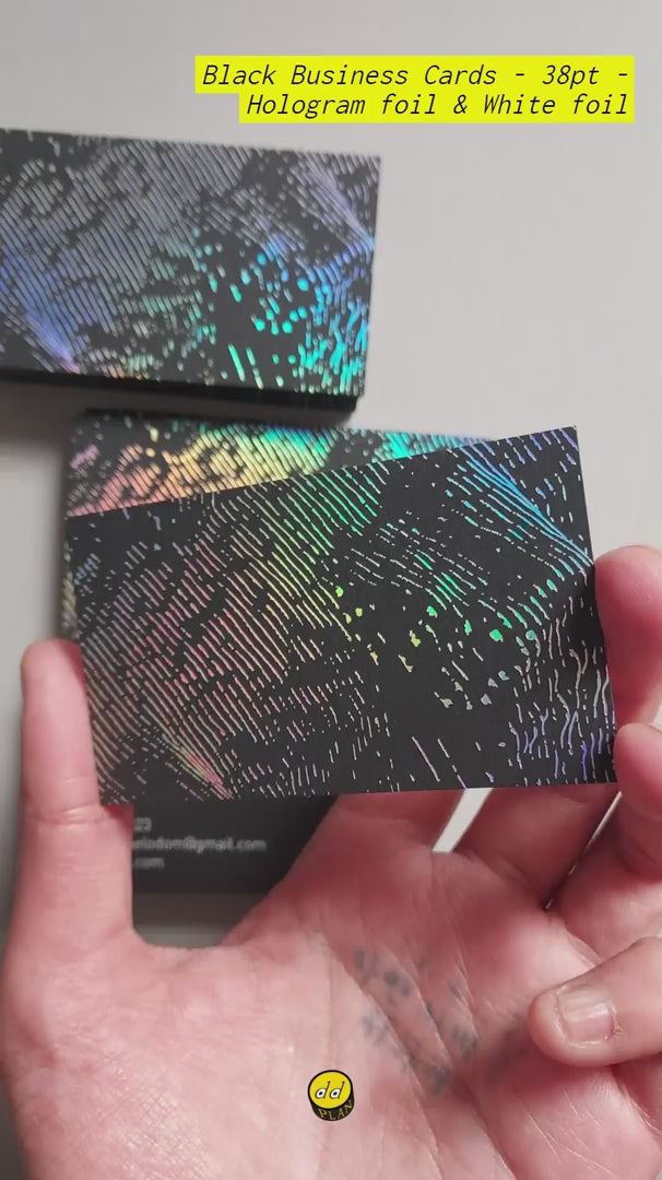 Black business cards on 38pt stock: weight, restraint, and a subtle holographic surface that shifts with light; white foil keeps names and numbers fixed and readable.