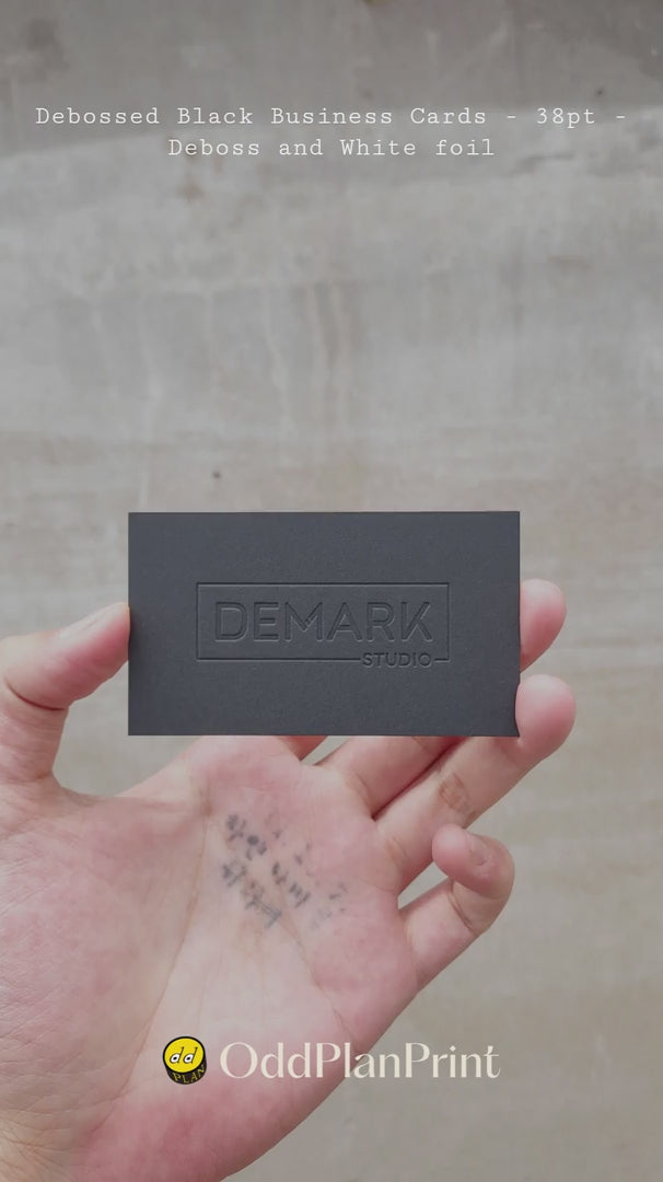 Elegant black business cards 38pt 700gsm with deboss and white foil accents produced by OddPlanPrint.