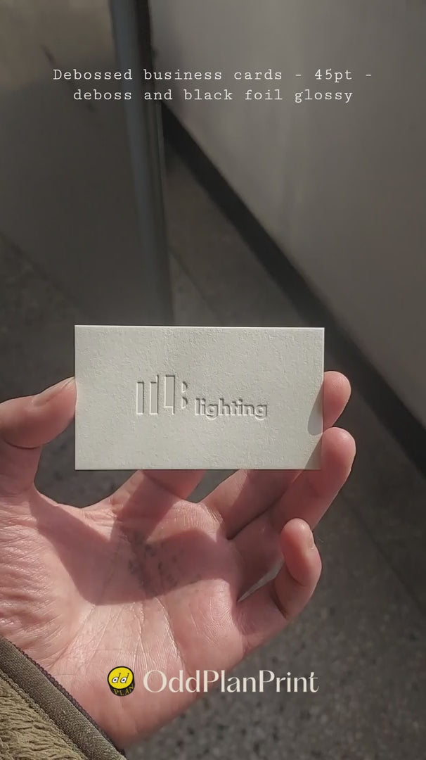 Textured 45pt cotton debossed business card by OddPlanPrint, featuring glossy black foil.