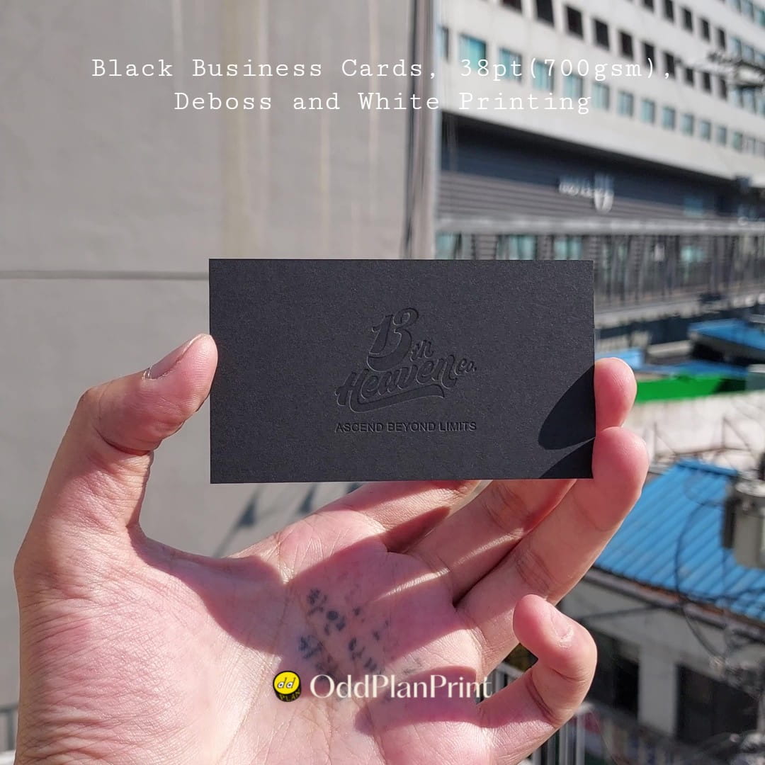 Thick black business cards using white printing and deboss. Made at OddPlanPrint.