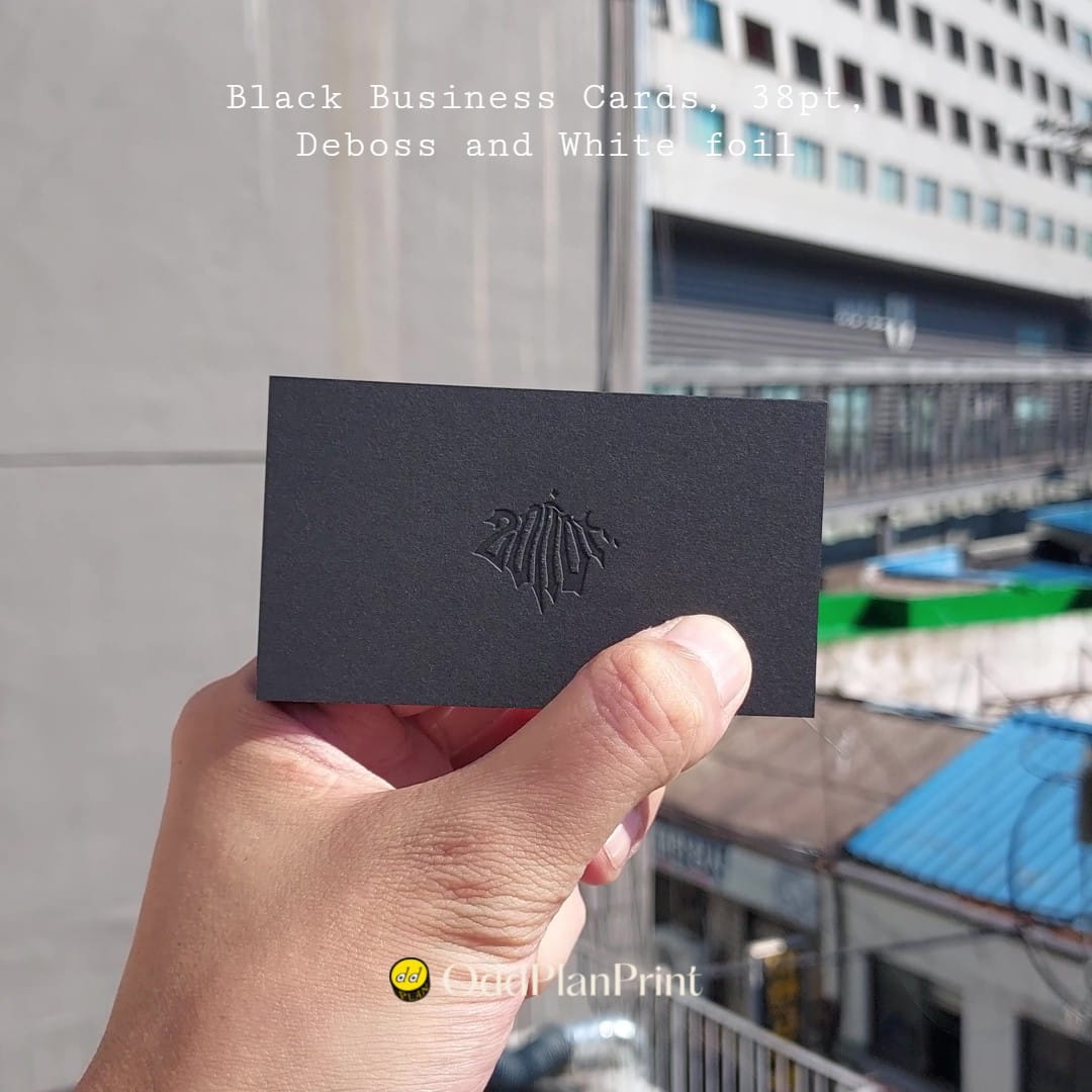 OddPlanPrint's thick black card uses a recessed mark and white foil for a polished impression.