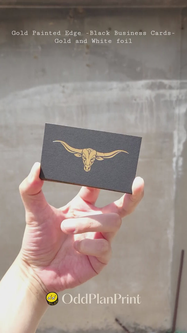 Premium black business cards displaying matte gold painted rims and dual gold and white foil pressing finished by OddPlanPrint.