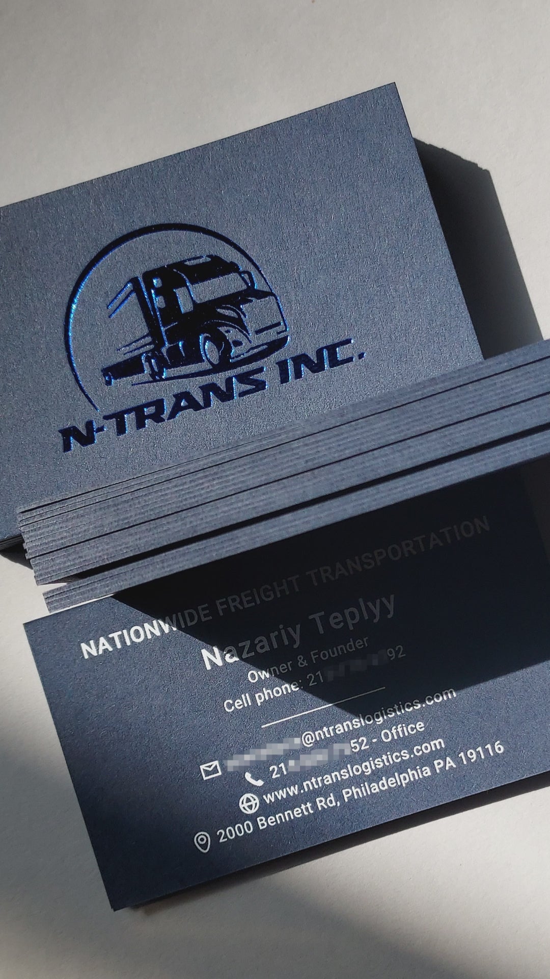 Sophisticated blue business card with deboss, foil, and rush delivery for small businesses.