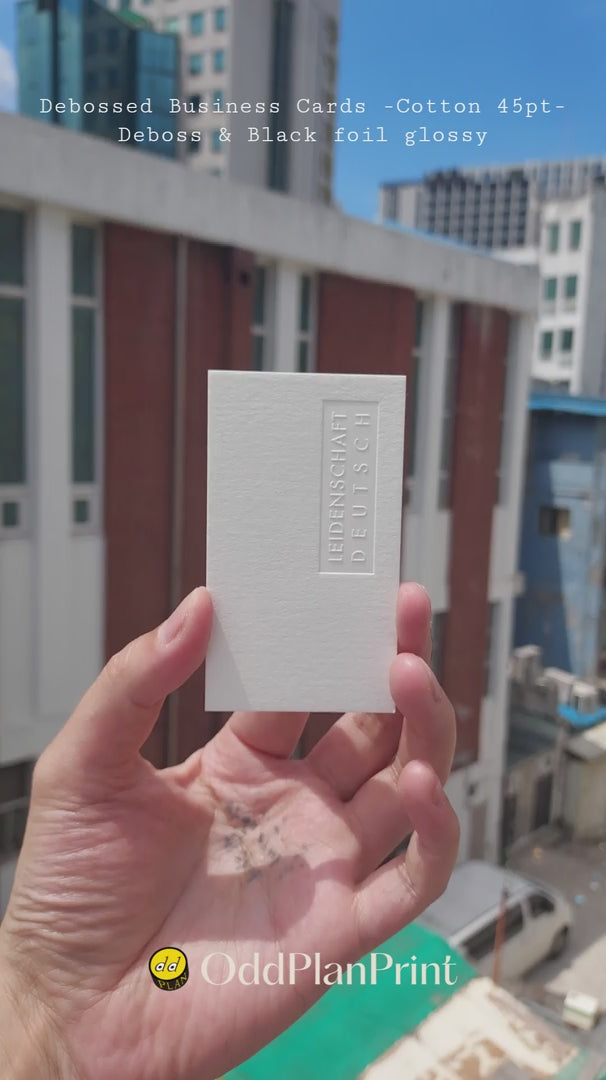 Debossed cotton business cards 45pt thick featuring deep deboss and glossy black foil by OddPlanPrint.