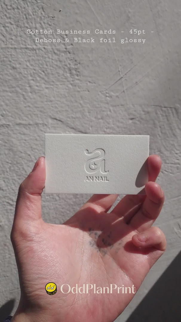 Deep deboss on 45pt cotton business card by OddPlanPrint. Black glossy foil adds sophisticated shimmer. Luxurious, tactile design for lasting brand impact.